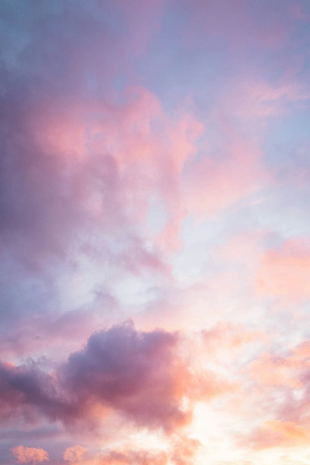 Rosa och lila moln på en ljus himmel
