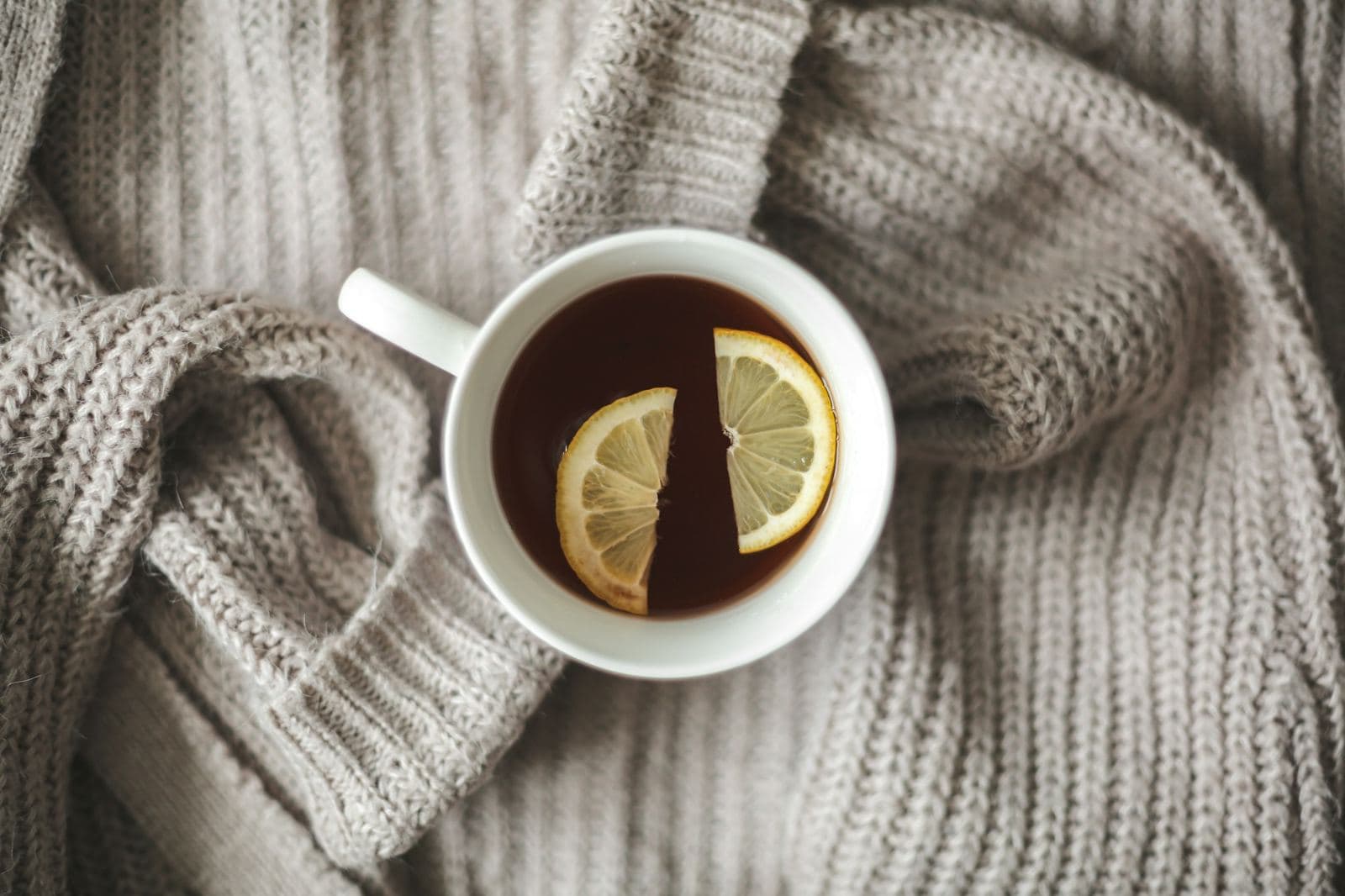 En kopp te med citron på en stickad tröja